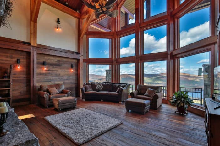 Custom timber frame home with large windows, natural wood accents, mountain views, and eco-friendly.