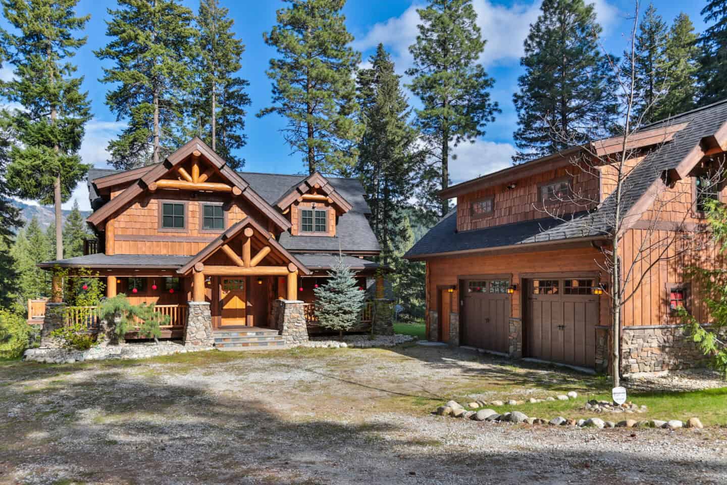 Rustic timber frame home with natural wood siding nestled among tall pine trees in a scenic mountain.